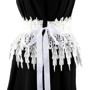 Detail of white embroidered lace corset belt with satin ribbon tie on black dress