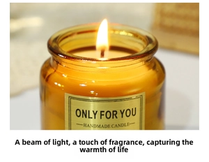Close-up of a lit handmade candle in an amber glass jar with a gold metallic label