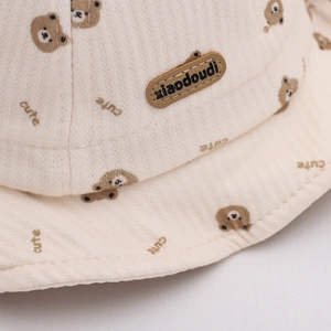 Detailed macro view of cream corduroy baby hat texture with bear and cute patterns
