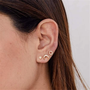 Gros plan de boucles d'oreilles S925 en or avec motifs d'étoile, lune et zircons