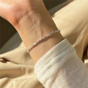 Close-up of sparkling S925 sterling silver chain bracelet on a woman's wrist
