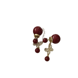 Elegant gold plated butterfly earrings with deep red pearls and sparkling zircon accents