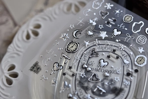Macro detail of silver 3D metallic nail stickers with star, moon and heart patterns