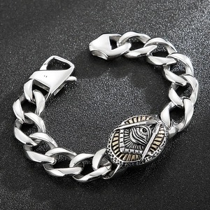 Detail of vintage silver Cuban chain bracelet with golden Freemason eye emblem