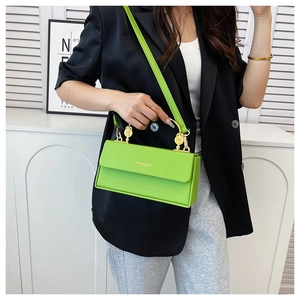 Détail d'un sac bandoulière carré vert en PU avec ferrures dorées et lettrage mode