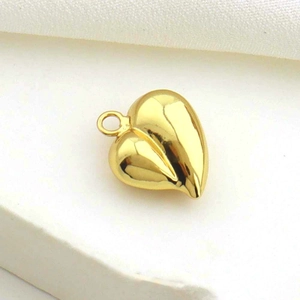 Polished gold heart charm pendant for DIY bracelets and necklaces on white fabric