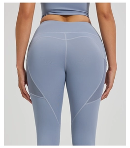 Detail view of high-waisted yoga leggings featuring mesh panels and heart-shaped back stitching