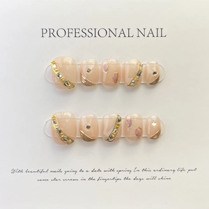 Faux ongles faits main rose nude avec feuilles d'or, strass et reflets violets brillants