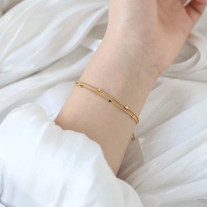 Detailed close-up of a double-layered 18K gold-plated titanium steel bead chain bracelet