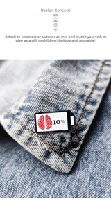 Makroaufnahme der Emaille-Anstecknadel mit Gehirn-Motiv auf blauem Denim-Stoff