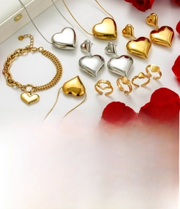 Detailed view of gold titanium heart jewelry set with necklace, ring, and rose petals