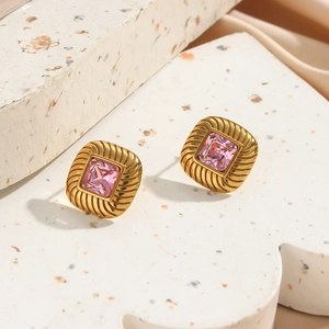 Macro shot of 18K gold plated square earrings with pink zircon and ribbed texture