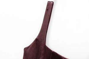 Macro shot of burgundy velvet fabric texture and strap detail on a corset dress