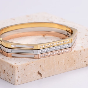 Three-piece set of hexagonal stainless steel bangles in gold, silver, and rose gold finishes