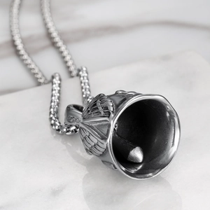 Macro shot of S925 sterling silver eagle wing bell pendant on a delicate box chain