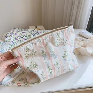 Close-up of floral print cotton makeup bag with secure zipper and soft quilted texture