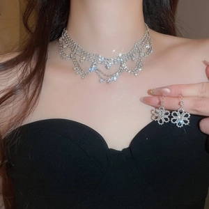 Close-up of sparkling floral rhinestone earrings and elegant multi-layered fringe necklace
