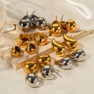 Minimalist gold and silver teardrop earrings displayed on a premium stone platform