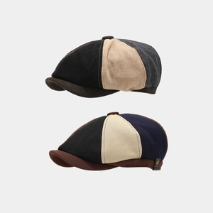 Detail of wool and canvas patchwork newsboy caps featuring metal side buckles