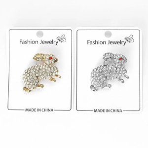 Detail view of crystal rabbit brooches in gold and silver finish with red rhinestone eyes