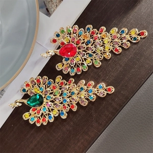 Detailed macro view of peacock brooches featuring colorful rhinestones and gold plating
