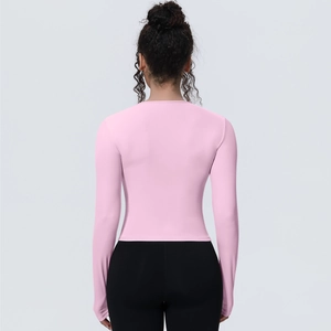 Haut de yoga ajusté rose pâle à manches longues, vue de dos montrant la coupe athlétique