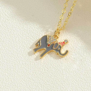 Macro shot of cute grey enamel elephant pendant with crystals on a delicate gold chain