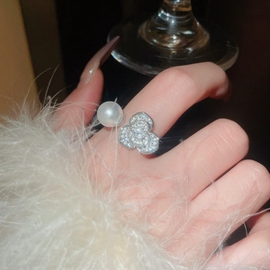 Détail de la bague ouverte avec perle et fleur en zircon au fini argenté de luxe