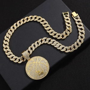 Close-up of gold iced out basketball pendant necklace with cubic zirconia Cuban chain