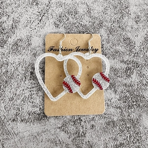 Détail de boucles d'oreilles cœur argentées scintillantes avec motif baseball