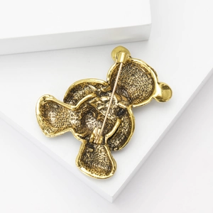 Detailed back view of vintage gold teddy bear brooch showing pin clasp and metal structure