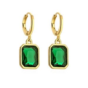 Detail of 18K gold-plated earrings with rectangular emerald zircon in macro view