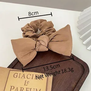 Morandi khaki bow scrunchie made of silky fabric with 13.5cm width on wooden tray