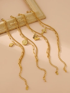 Détail de colliers dorés multicouches avec pendentifs trèfle, pièce, papillon et croix