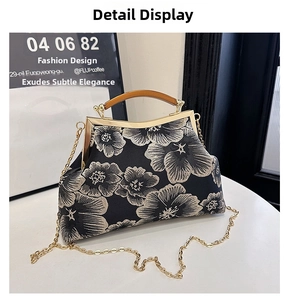 Detailed close-up of retro floral embroidery on black satin with wooden top handle