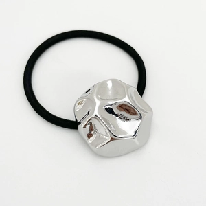 Macro shot of silver metallic irregular geometric bead on a black elastic hair tie