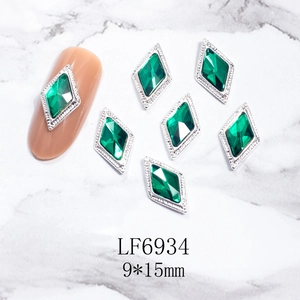 Vista macro de cristal para uñas rombo verde esmeralda 9x15mm con borde plateado