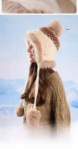Detailed knit winter hat with plush faux fur trim and three fluffy pom-poms shown on model