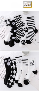 Detailed view of assorted black and white cotton socks with cartoon bear and grid patterns