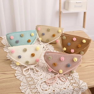 Collection of colorful handmade straw shoulder bags with vibrant pom-poms for children