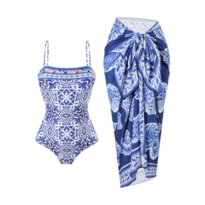 Blue Mediterranean floral one-piece swimsuit and matching wrap skirt set detail