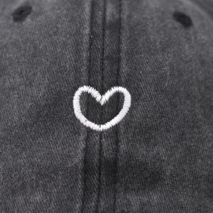 Washed dark gray cotton baseball cap with a small white embroidered heart on the front