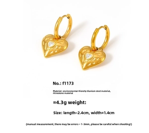 Detail of 18k gold plated heart earrings with hammered texture and sparkling rhinestones