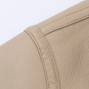 Macro shot of apricot faux leather texture and premium stitching on women's jacket