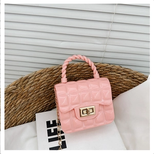 Detailed shot of a pink quilted jelly bag with gold chain strap in a woven basket
