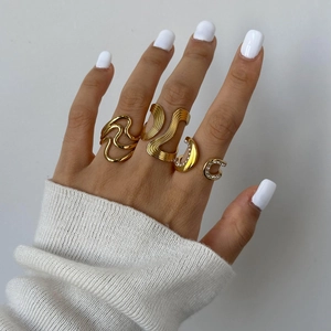 Women's gold plated stainless steel wave rings with crystals on model's hand