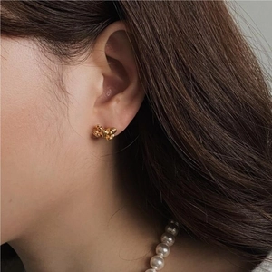 Elegant 925 silver gold knot bow stud earrings worn by a model in a close-up profile shot