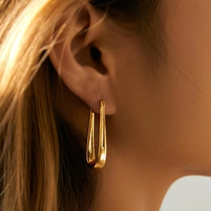 Elegance 18K gold plated U-shaped drop earrings shown on model in a minimalist style