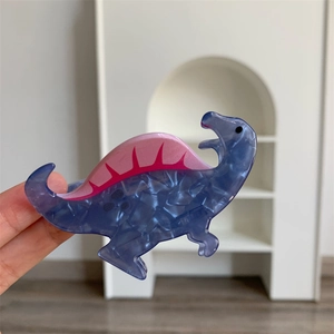 Detail of blue marble texture acrylic dinosaur hair claw clip with pink zigzag accent