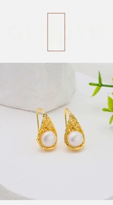 Close-up of bird nest style pearl earrings with 18k gold plated woven wire detail